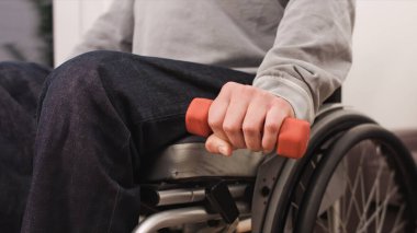 Tekerlekli sandalyedeki adam egzersiz yapıyor.