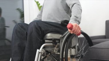 Tekerlekli sandalyedeki adam egzersiz yapıyor.