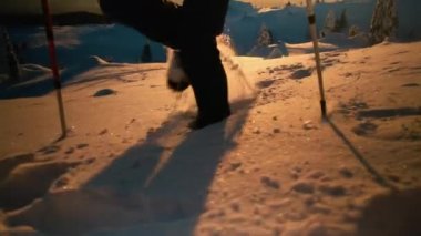 Gün batımında karlı mointain 'de yürüyüş yapan kadın.