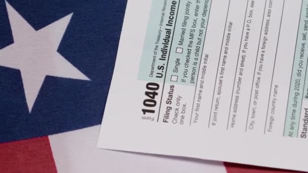 1040 φορολογικό έντυπο στην αμερικανική σημαία — Αρχείο Βίντεο