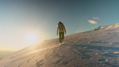 Karlı dağlarda yürüyüş yapan bir kadın