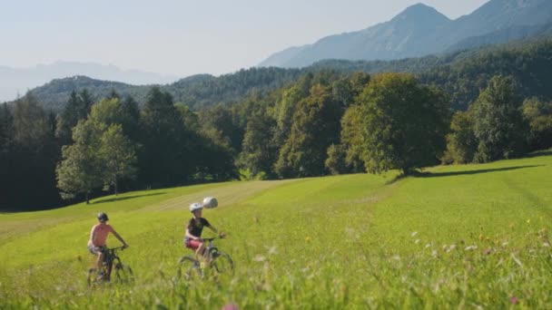 Två kvinnor rider mountainbike i naturen — Stockvideo