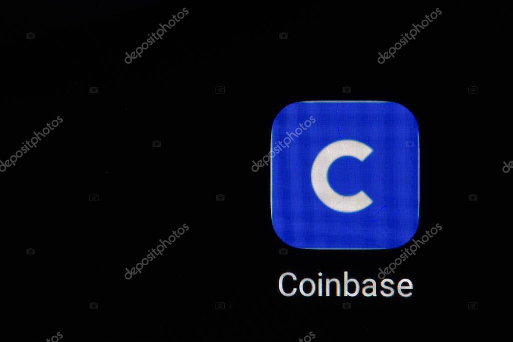 Coinbase logo on screen with Bitcoin coins. Ljubljana, Slovenia - April 06 2021