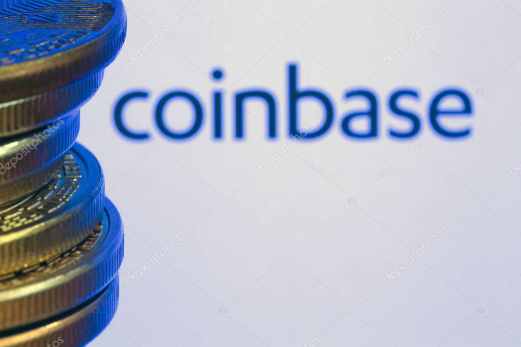 Coinbase logo on screen with Bitcoin coins. Ljubljana, Slovenia - April 06 2021