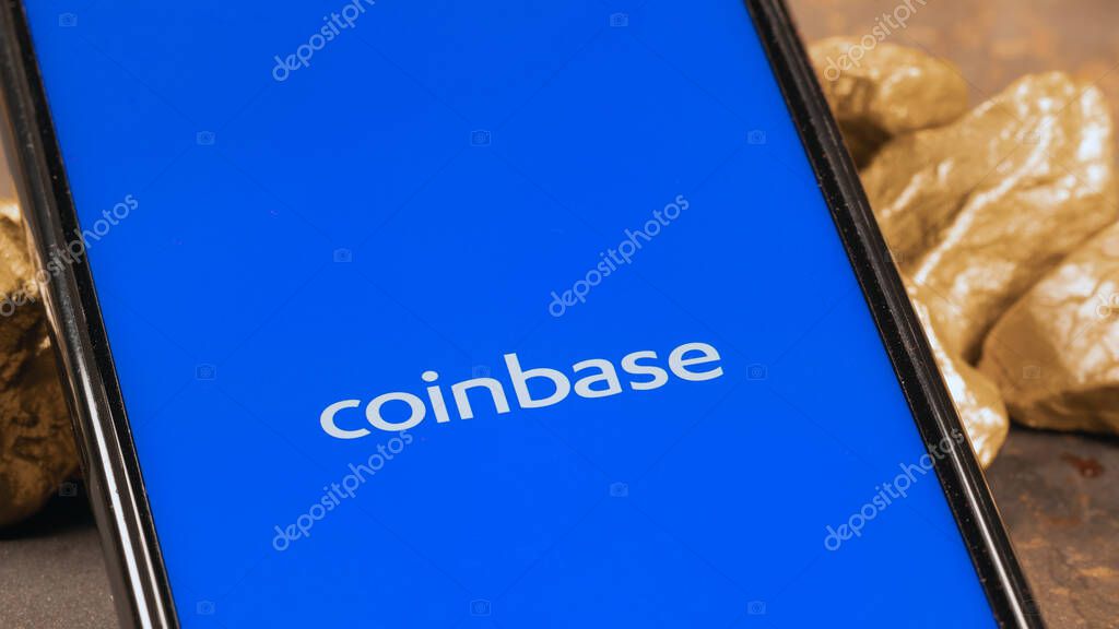 Coinbase crypto exchange logo on screen with gold. Ljubljana, Slovenia - April 12 2021