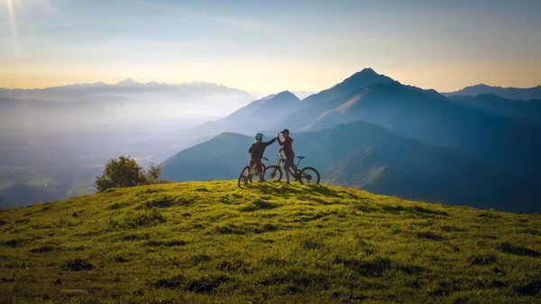 Mujer alta cinco sobre el atardecer en el viaje en bicicleta de montaña —  Fotos de Stock