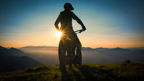 Woman on mountain bike at sunset