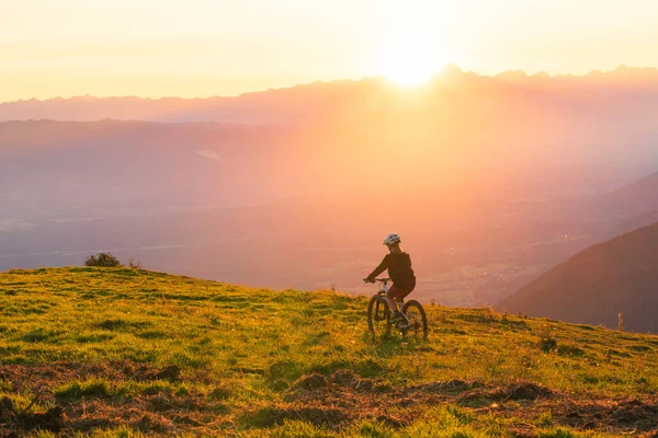 Niña montando bicicleta de montaña en el atardecer —  Fotos de Stock