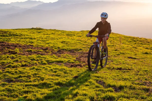 Menina criança montando bicicleta de montanha para o pôr do sol — Fotografia de Stock