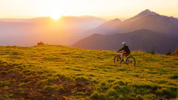 Niña montando bicicleta de montaña en el atardecer — Foto de Stock