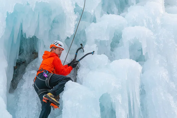 Escalador balançando os eixos de gelo — Fotografia de Stock