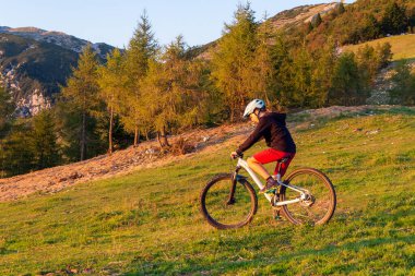 Dağ bisikletine binen kız gün batımına doğru