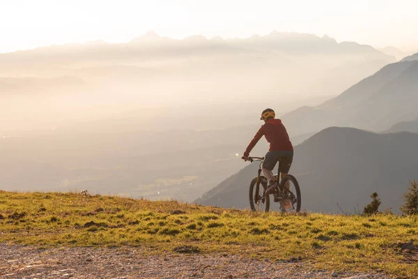 Mujer montando bicicleta de montaña en el atardecer —  Fotos de Stock