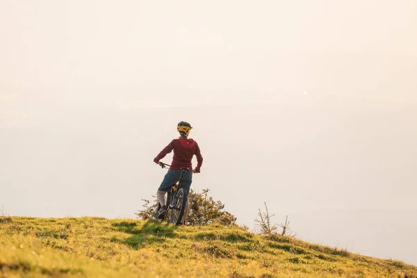 Woman on mountain bike at sunset — Stock Photo, Image