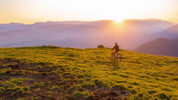 Niña montando bicicleta de montaña en el atardecer —  Fotos de Stock