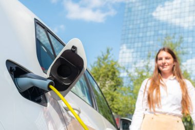 Elektrikli araba şarj aletinin fişini çekiyorum.