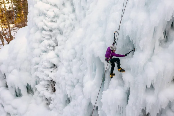 Jéghegymászó egy fagyott vízesésnél — Stock Fotó
