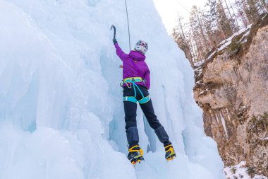 Buzlu yamaca tırmanan bir kadın