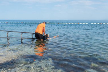 Tekerlekli sandalyedeki adam rampadan denize