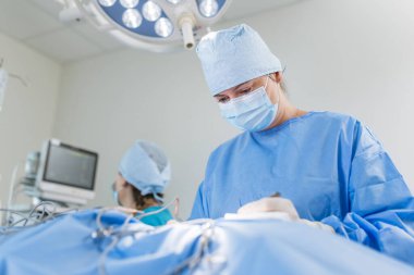 Yetenekli tıp uzmanları, steril bir ortamda hastanın düzgün bir şekilde tedavi edilmesini sağlamak için ameliyata alınır..
