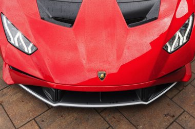 Slovenya, Ljubljana - 9 Ekim 2025: Lamborghini Huracan STO ıslak bir yüzey üzerinde parlak kırmızı bir finalle öne çıkıyor.