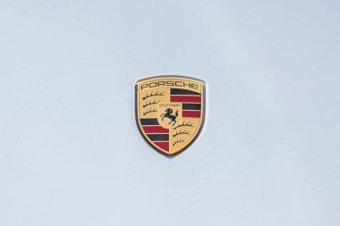 Slovenya, Ljubljana - 5 Kasım 2025: Porsche 911 Carrera GTS rozeti açık mavi gökyüzüne çarpıyor.