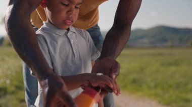 Babası çocuklarına bakıyor cilt koruması ve güneş kremi sürüyor. Küçük oğluna güneş kremi sürüyor. Yakın çekim..