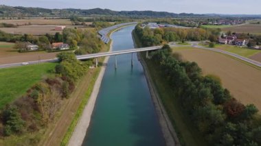 Nehir boyunca yeşil bir enerji tesisinin yakınına kurulmuş güneş panelleri yenilenebilir enerjiyi iş başında gösteriyor..