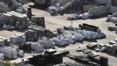 Bir hurda metal geri dönüşüm tesisinin hava görüntüsü sıralanmış büyük metal malzemelerin işlenmeye ve geri dönüşüme hazır olduğunu gösteriyor.