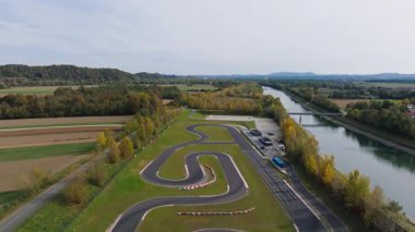 Karting pisti ağaçlarla dolu tarlalarda ve gün ışığında açık bir gökyüzünün altında bir nehirde sürükleniyor..