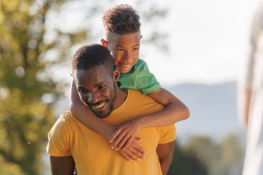 Bekar bir baba ve oğlu, gün batımında neşeli aktiviteler yaparken dışarıda eğlenceli anlar yaşıyor..