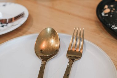 Altın kaşıklı boş beyaz tabak ve çatal masa seti. Uzayı kopyala Mutfak çatal bıçak takımı..