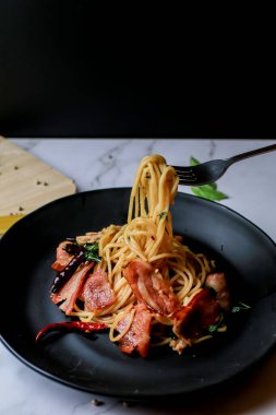 Çatal kıvrımlı spagetti pastırması, sarımsak, fesleğen, kurutulmuş kırmızı biber. Sıcak ve baharatlı yemekler, uluslararası yemekler.