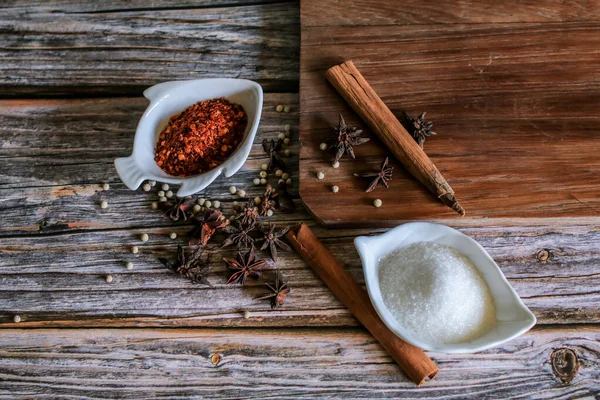 Chili powder and sugar with five spices (cinnamon, fennel, star anise, pepper, clove) to make noodle soup.