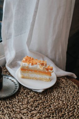 Karamel ve bademle kaplı nefis bir badem kremalı pasta. Tabakta bir parça kek var. Tatlı yemek. Tatlı tatlı.