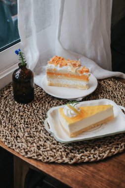 Karamelli ve limonlu peynirli pastayla kaplı nefis bademli krem şanti. Tabakta bir parça kek var. Tatlı yemek. Tatlı tatlı.