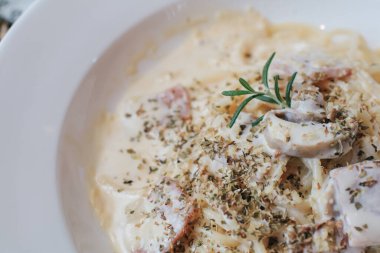 İtalyan makarnası - Pancetta, yumurta, parmesan peyniri ve krem soslu spagetti carbonara. Tahta masadaki beyaz tabakta. .