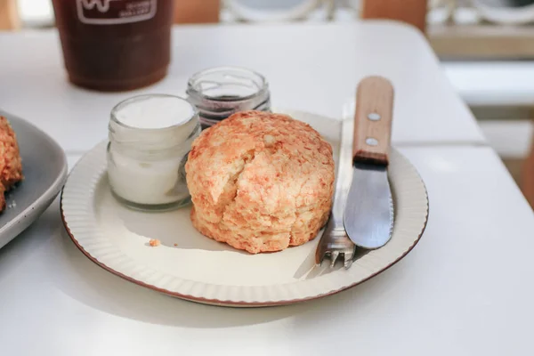 白いテーブルの上にストロベリージャムとクロットクリームのおいしいスコーン 英語のペストリーコンセプト — ストック写真