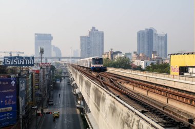 Bangkok, Tayland-23 Ocak 2021: BTS tren istasyonundan gökyüzü tren istasyonuna kadar Bangkok şehrini kaplayan başbakandan 2.5 toz bulutu ile günbatımı ve bulutlu gökyüzü.
