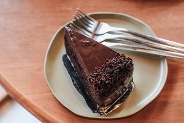 Bir dilim lezzetli çikolatalı pasta. Beyaz bir tabakta bir parça kek. Tatlı yemek. Tatlı tatlı. Kapatın. Seçici odak.