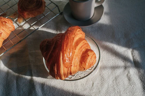 Coffee with croissant so delicious under sunlight. Perfect breakfast in the morning.