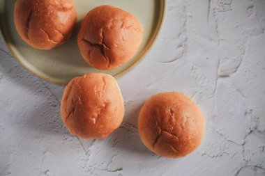 Taze pişmiş ekmek. Beyaz arka planda organik tam buğday somunları. Mini ekmek yığını. Fırın ekmeği ticareti..