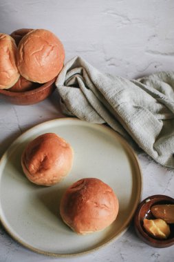 Gri arka planda kahvaltı için ev yapımı ekmek ve tereyağı. Sabah kahvaltısı, çay, tereyağı ve tost. Geleneksel İngiliz çörekleri