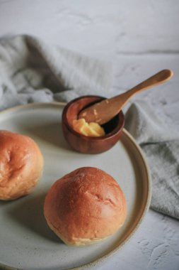 Gri arka planda kahvaltı için ev yapımı ekmek ve tereyağı. Sabah kahvaltısı, çay, tereyağı ve tost. Geleneksel İngiliz çörekleri