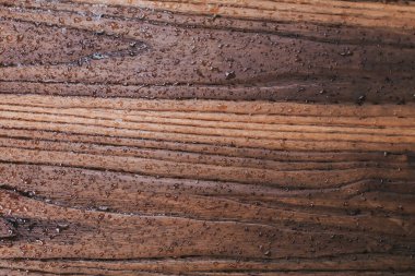 Yağmur sırasında kahverengi ahşap bir yüzeye su damlalarını kapatın, soyut arkaplan, sığ alan derinliği