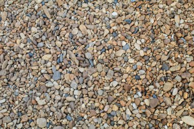 Yuvarlak çakıl taşlarıyla soyut bir arkaplan. Güzel çakıl, doğal taşlar. Metin için arkaplanda boş alan.