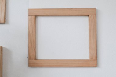 Beyaz duvardaki ahşap çerçeve. Oturma odasının içinde sahte fotoğraf çerçeveleri var. Ev dekorasyonu tasarla.