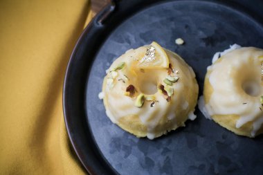 Sarı ve siyah arkaplanlı şekerli limonlu pasta. Turtalı kek, haşhaşlı, geleneksel Amerikan mutfağı koyu tonda.