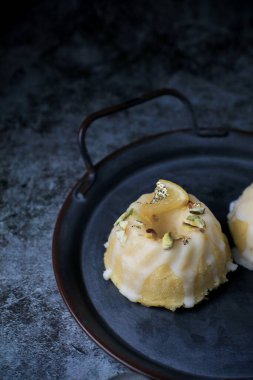 Sarı ve siyah arkaplanlı şekerli limonlu pasta. Turtalı kek, haşhaşlı, geleneksel Amerikan mutfağı koyu tonda.