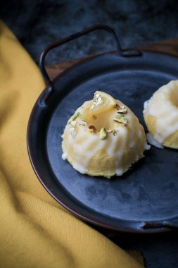 Sarı ve siyah arkaplanlı şekerli limonlu pasta. Turtalı kek, haşhaşlı, geleneksel Amerikan mutfağı koyu tonda.